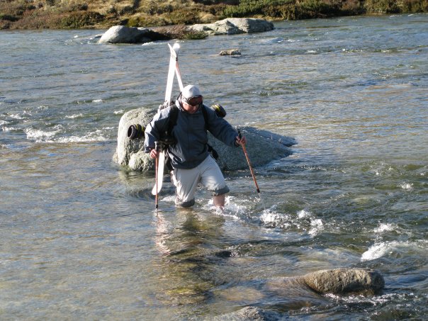 Andrew 'Snowy' Snow crossing the Snowy River after hiking the Main Range for some skiing