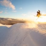 Skiier jumping out of gully