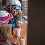 A family enjoying hot chocolate after a day of skiing at Sun Peaks Resort.