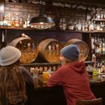 Two friends having a drink together at RMU restaurant in Whistler Village.