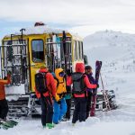 Skiers unload from Snowcat heading downhill at Skeena Cat Skiing