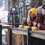 A trio of skiers enjoying lunch and coffee at Kicking Horse Mountain Resort.