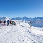 Skiers at Tete des Lindars – the highest point in the Grand Massif ski area, with views towards Mont Blanc.